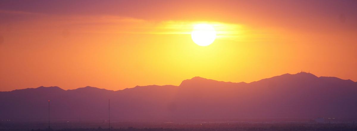 The sun setting over distant mountains in the Phoenix area